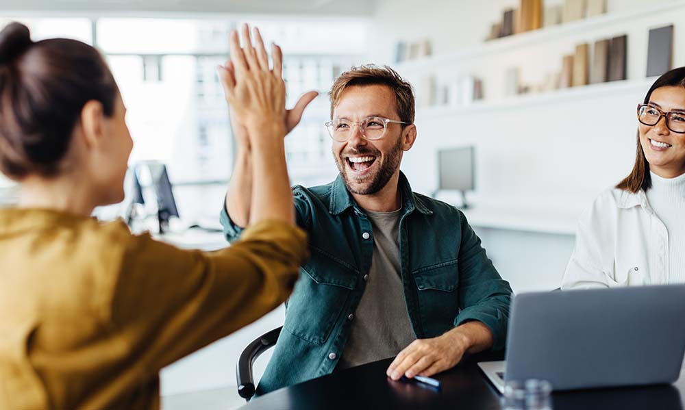 Office workers giving a high five